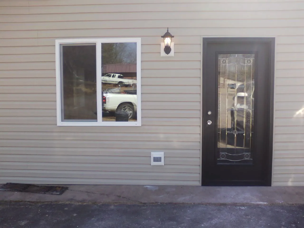 New siding, window and entry door on the side of an addition in Cutler