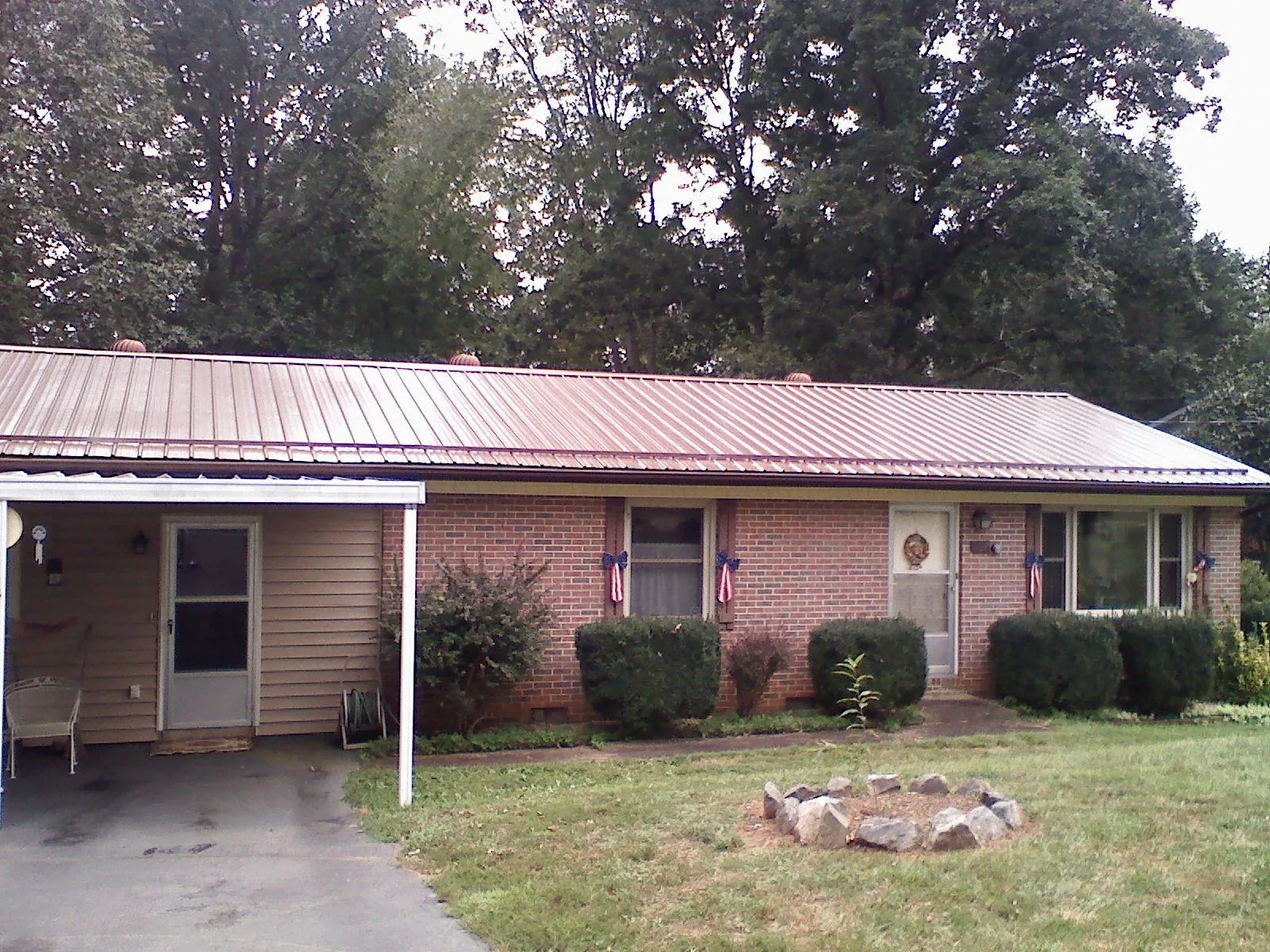 Bronze metal roof and carport on a brick ranch home — Roof Repair work by our crew in Cutler